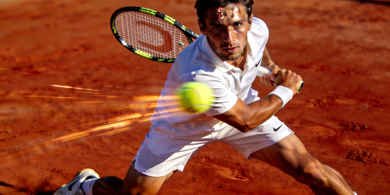 网球运动员在红土场上挥拍击球的专业动作